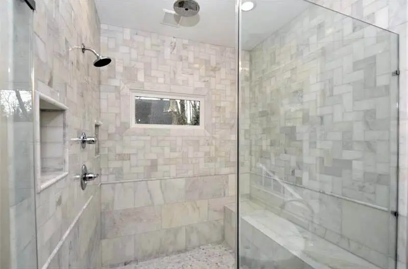 Bathroom shower with bench and marble field tile
