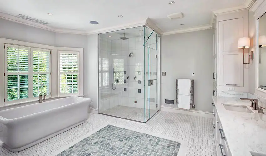 Tub, windows with blinds and white granite countertop