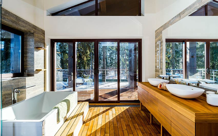 Bathroom with teak wood countertop vanity and flooring with outdoor views