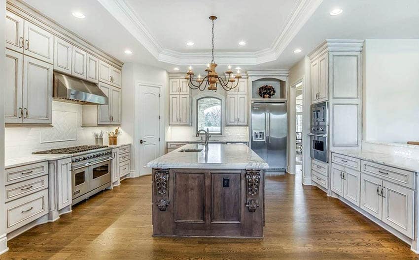 Kitchen with walnut floors, antique white painted cabinets and carrara marble countertops