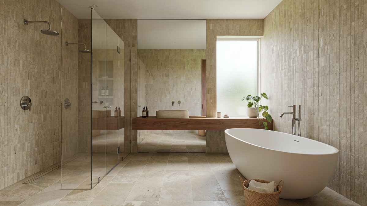 Glass shower with twin rainfall heads next to a freestanding oval tub