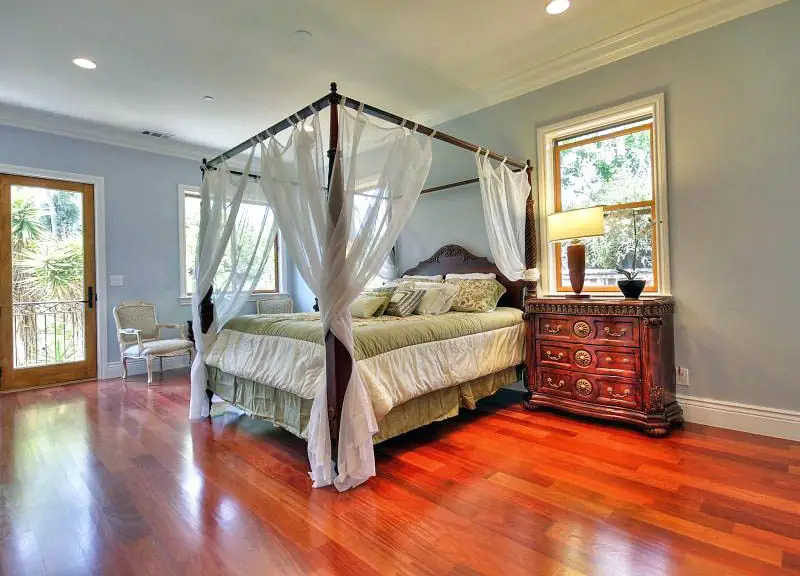 Bedroom with cherry wood floors and four post bed