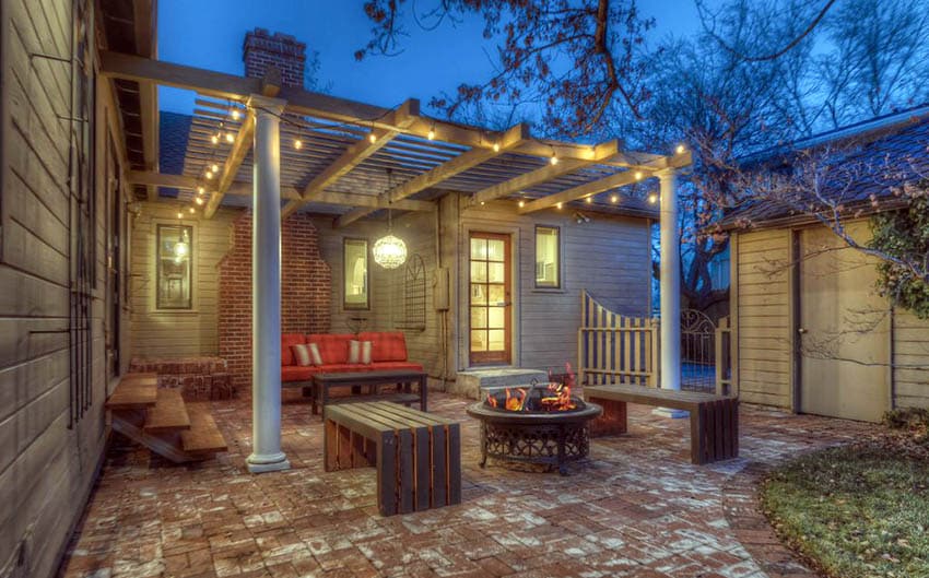 fire pit pergola with custom wood benches and brick patio