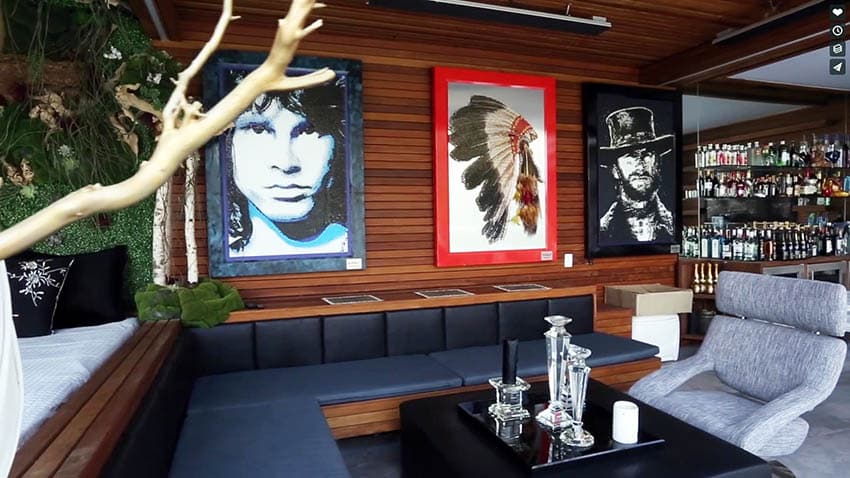 Celebrity art man cave decor with wet bar and bench seating