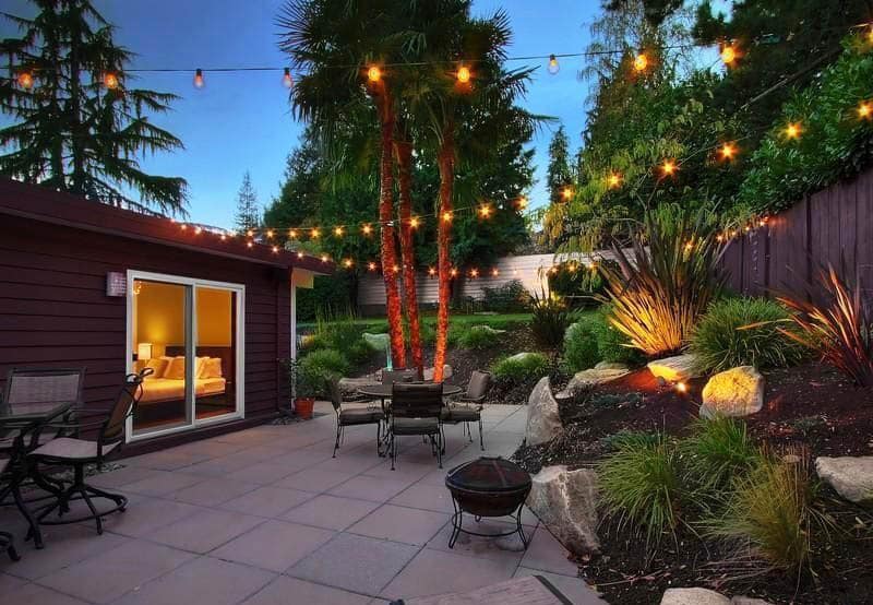 Concrete patio with string lights and landscaping