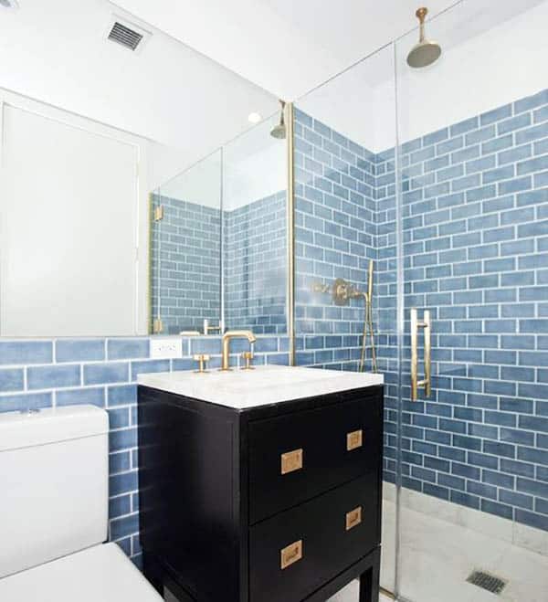 Bathroom with blue tile and sink with gold finishes