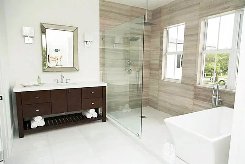 Bathroom with ceiling mounted rainfall shower head and freestanding tub
