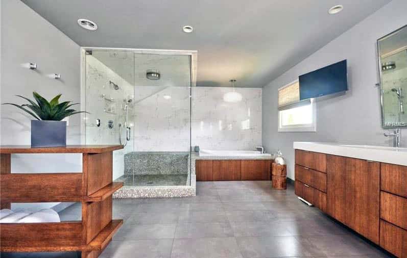 Contemporary bathroom with polished marble shower with tv