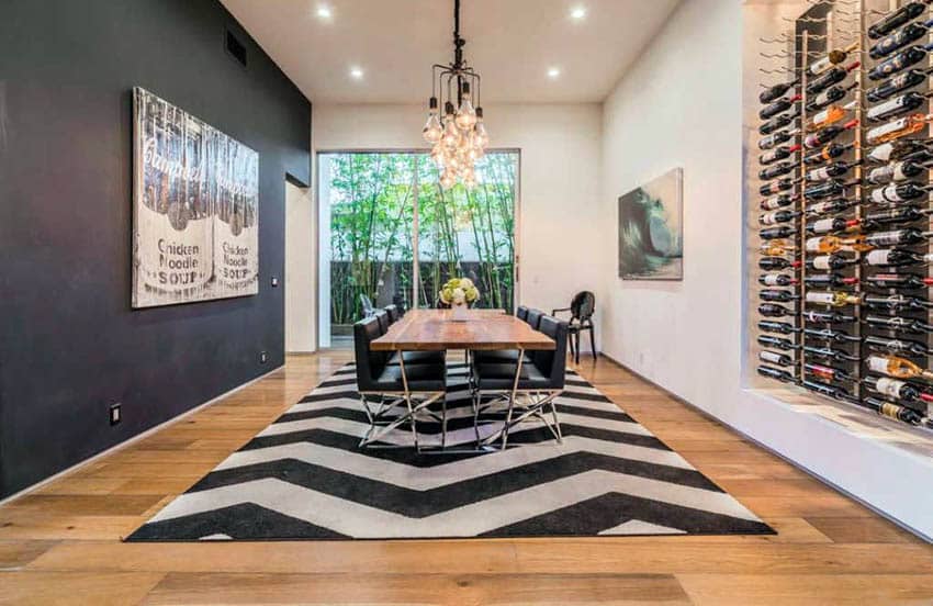 Room with black painted accent wall, chandelier, wood table with steel legs and black chair