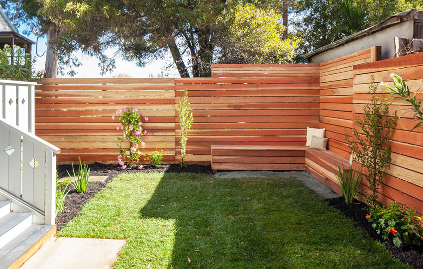 Contemporary privacy fence with horizontal design and wood sitting bench