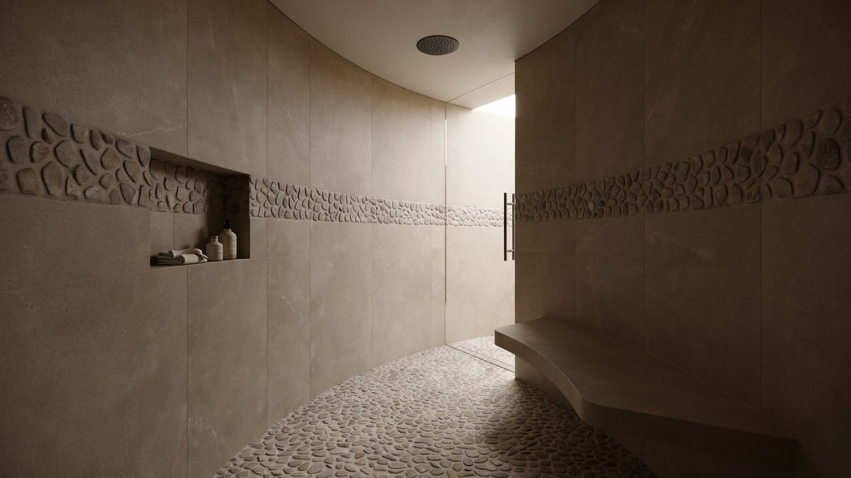 Curved brown travertine walls with river rock banding and a low bench