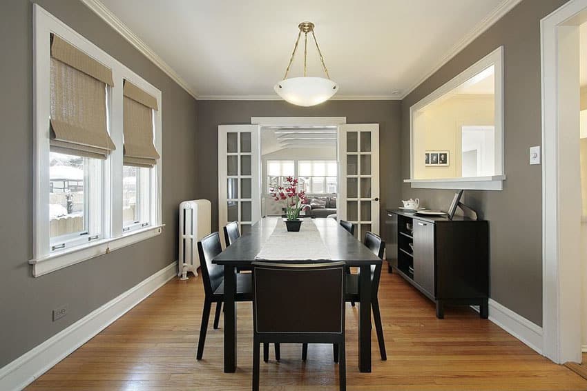 Dining room with dark table and chairs with white french doors and bronze wall paint