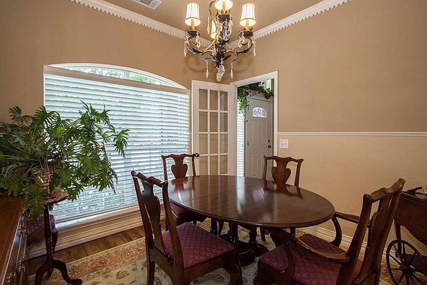 Dining room with single french door and wood oval dining table