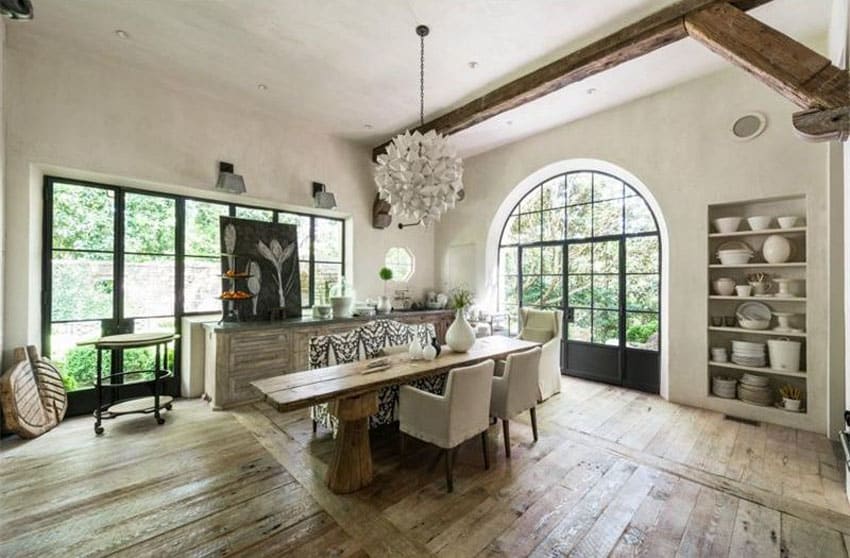 Expansive dining room with arched entry french doors and wood beam ceiling
