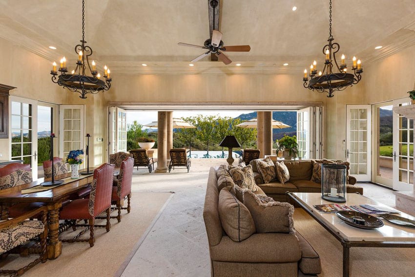Indoor outdoor living room with french doors and wrought iron chandeliers
