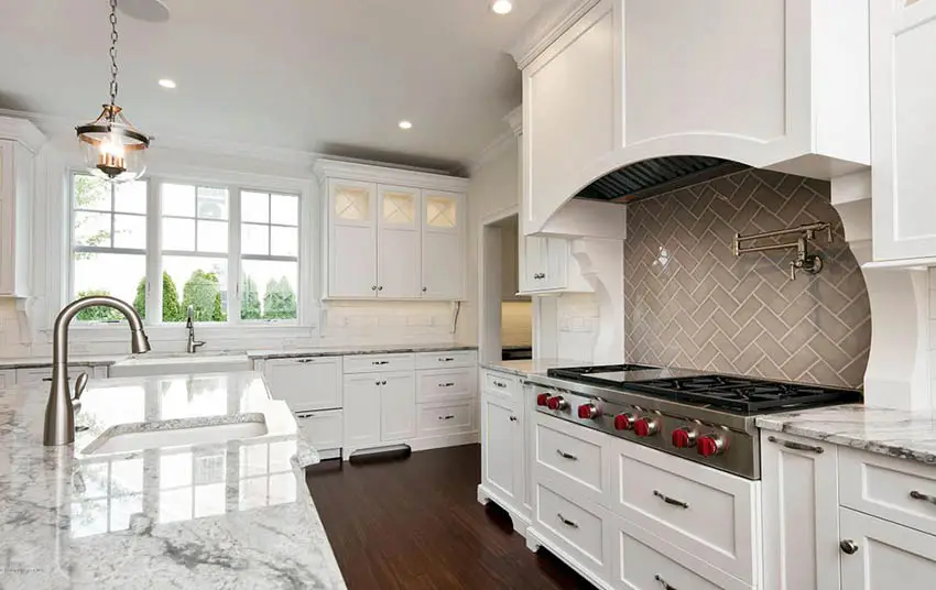 Kitchen with marble countertop, single hung windows and backsplash tiles in basketweave pattern