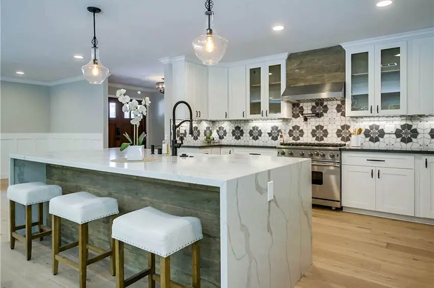 Kitchen with gooseneck faucet white quartz waterfall counter island distressed wood and white cabinets