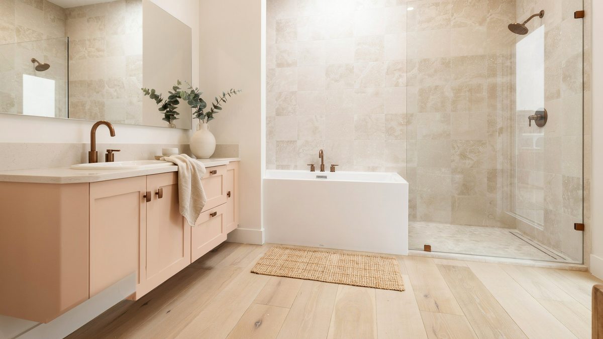 Blush pink vanity facing a rectangular tub and glass travertine shower