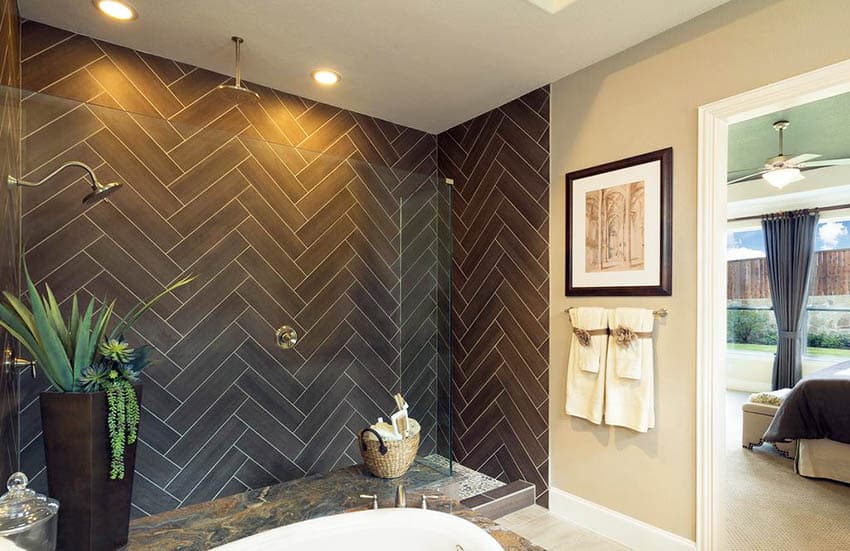 Master bathroom with doorless shower with herringbone pattern porcelian tile