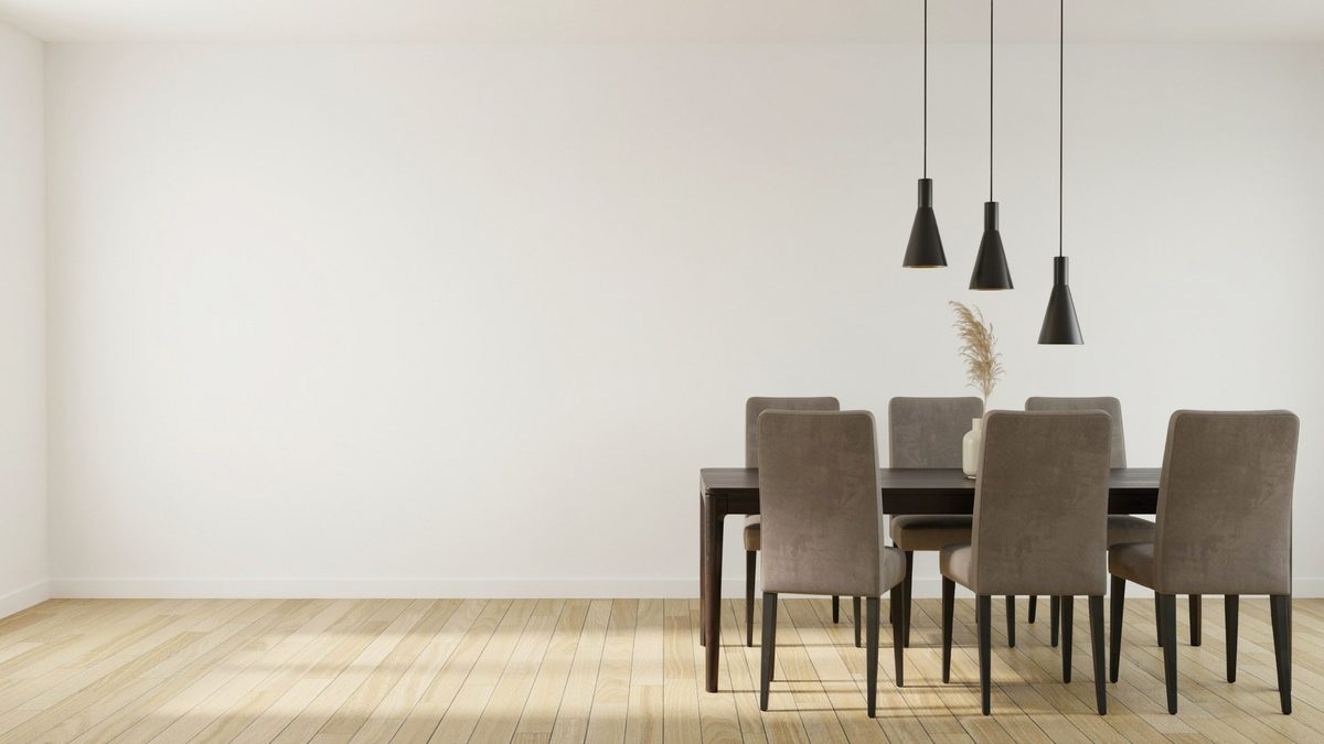 Dark wood table with taupe velvet chairs under three black cone pendants