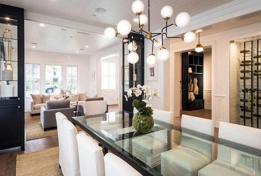 Modern dining space design with glass table, white chairs and sputnik chandelier