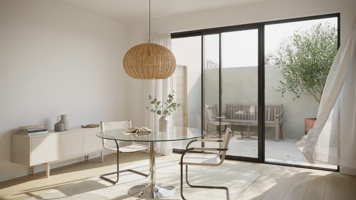 Glass pedestal table beside black framed sliding doors leading to a patio