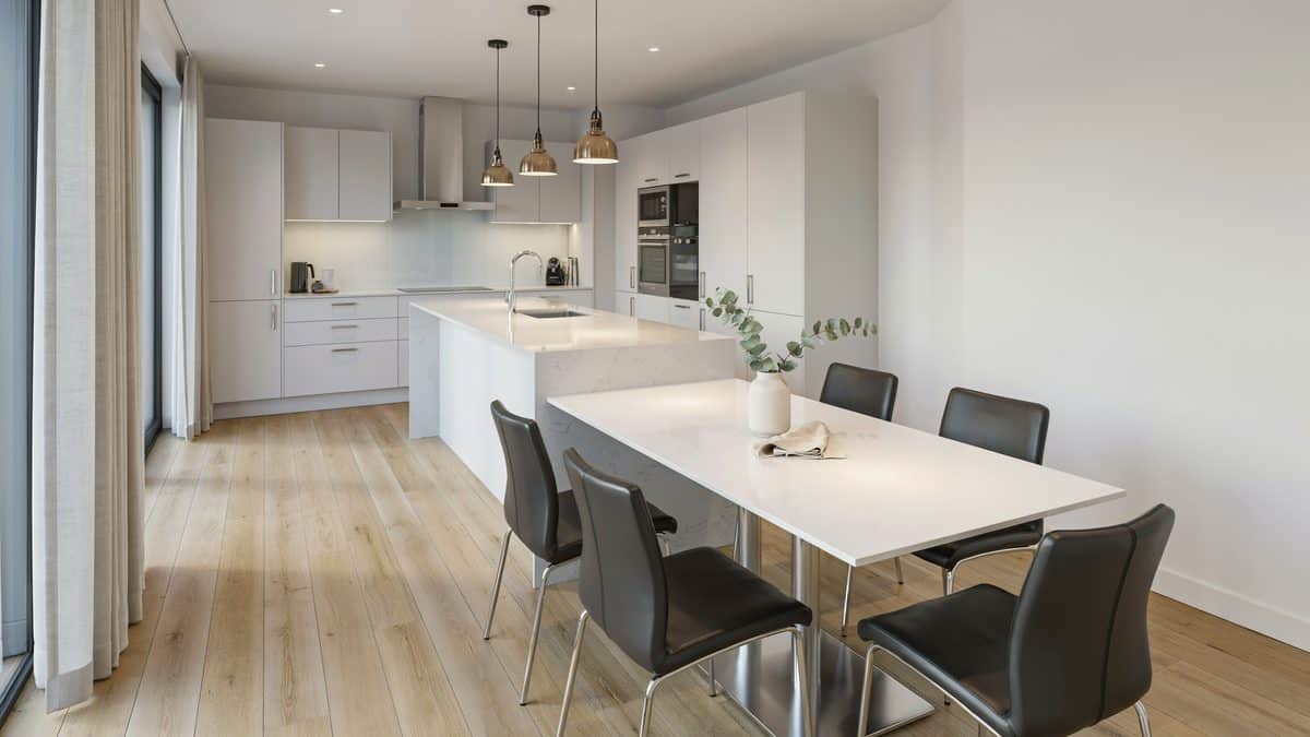 White laminate table with dark chairs facing a long white kitchen island