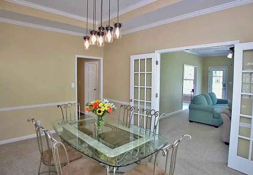 Traditional dining space with pendant lighting and a vase with daisies