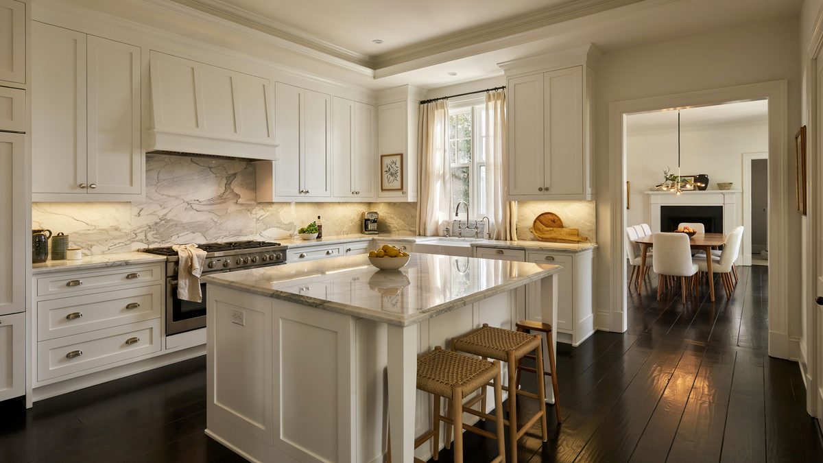 Raised panel white cabinets and marble counters over dark ebony floors