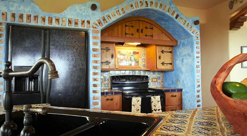 Traditional Spanish kitchen with colorful ceramic tile countertops and concrete arch