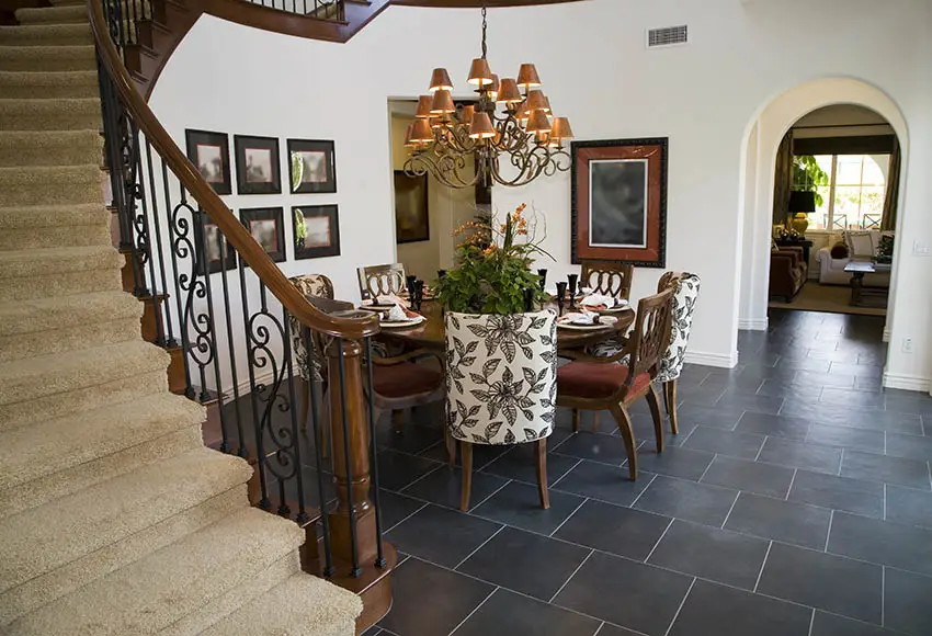 Mediterranean style dining space with round table and chairs and black floor tiles