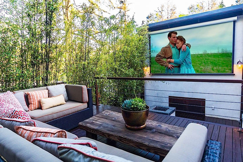 Contemporary wood deck with outdoor projector tv and couches