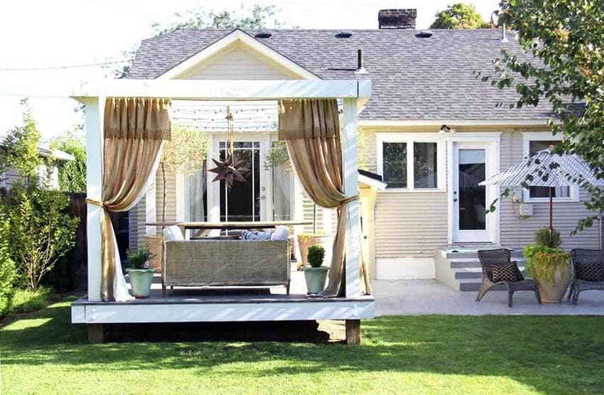 Freestanding deck with pergola and privacy curtains