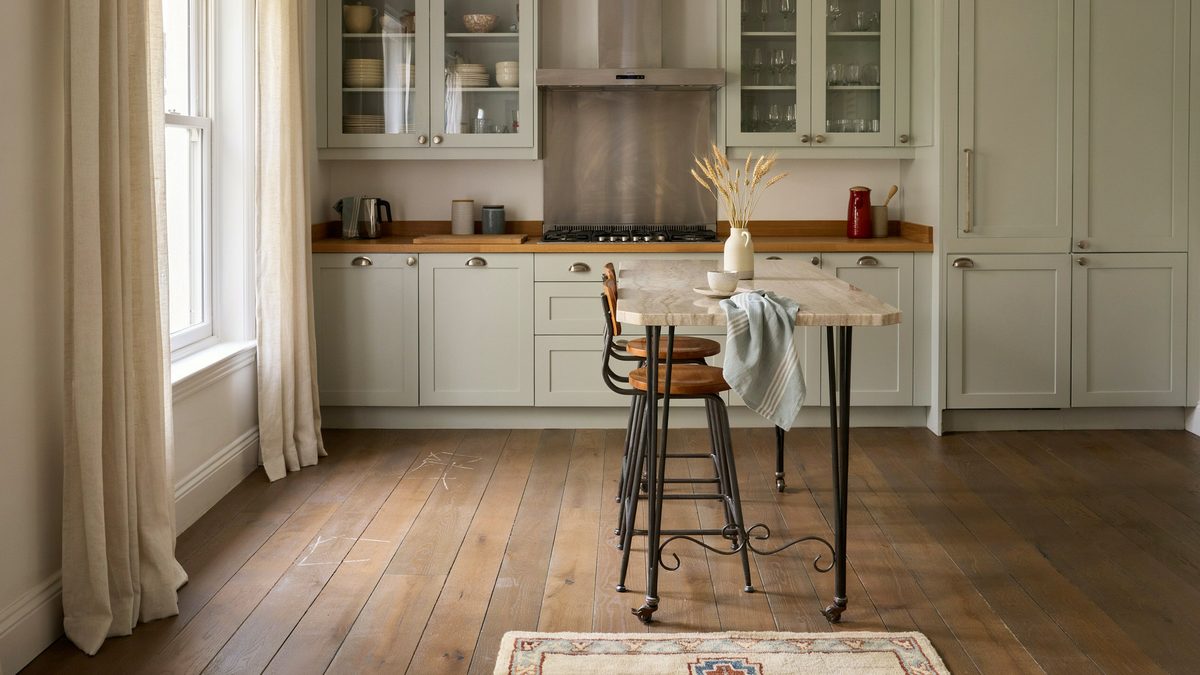 Wrought iron island with beige granite top and two metal bar stools