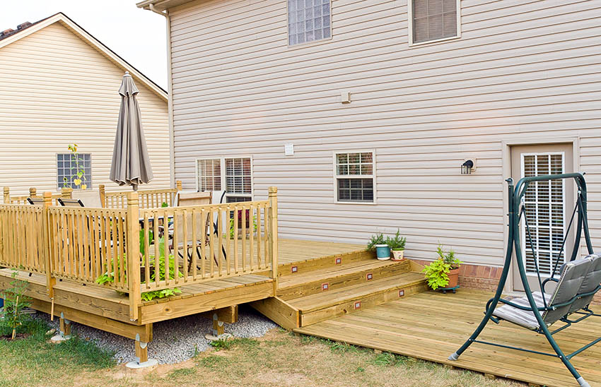 Multi level wood deck with railing balusters and swing
