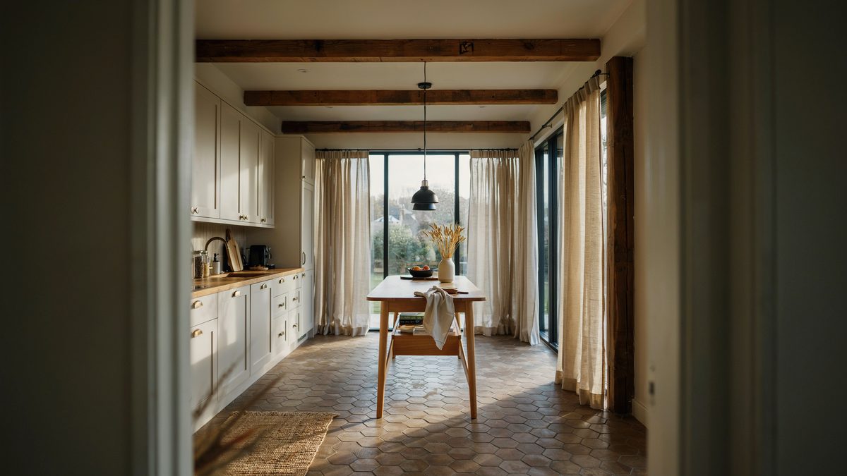 Narrow maple island in a beamed kitchen with hexagonal floor tiles