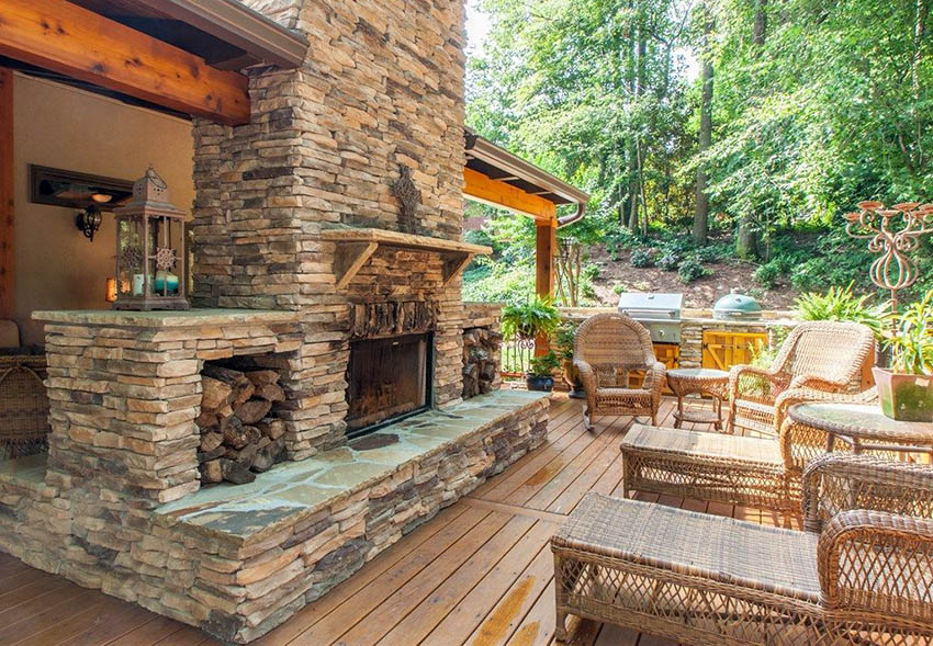 Wood deck with outdoor fireplace made of stacked stone and wicker furniture