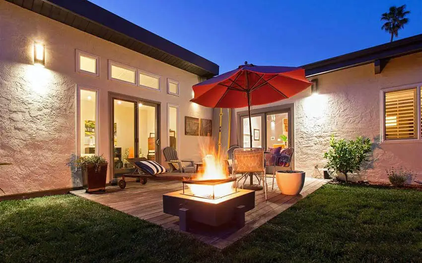Deckl with sunken put, chaise lounges and red umbrella