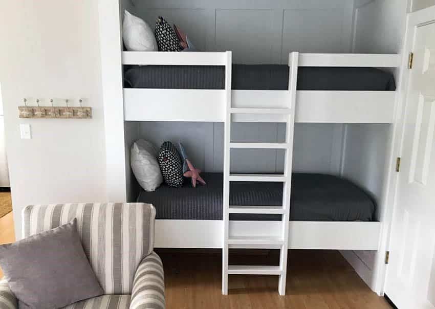 Bedroom with white built in bunk beds with ladder