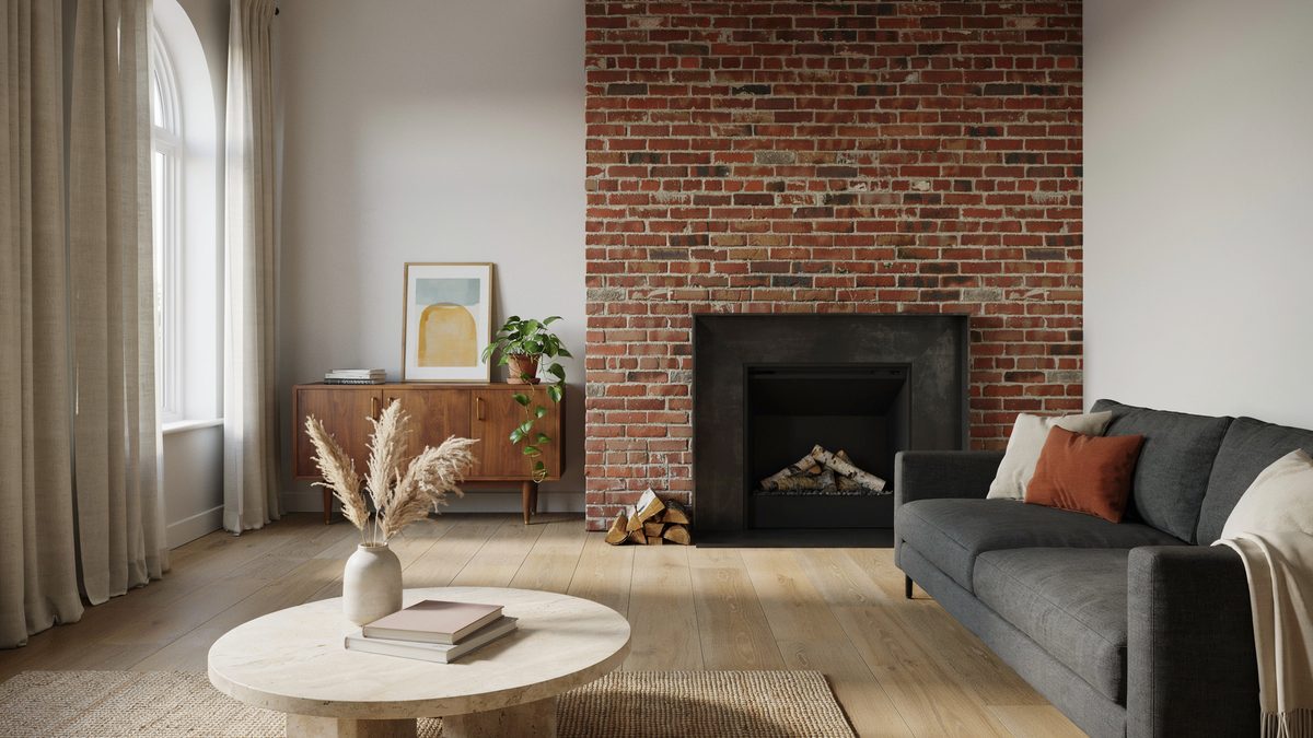 Light oak plank floor running past a red brick fireplace wall and walnut sideboard