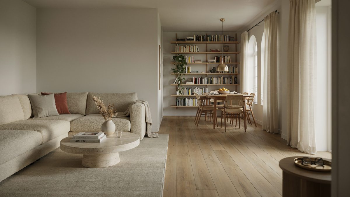 Pale wide plank oak stretching from the sofa back to a bright dining nook