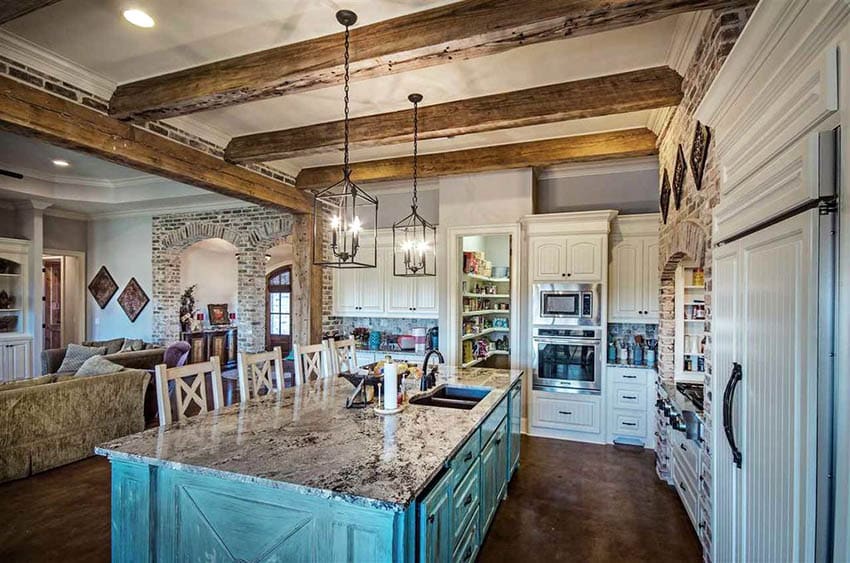 Country style kitchen with white raised panel beadboard cabinets and distressed green island