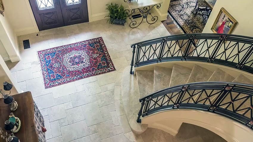 Foyer with french provincial railing staircase and travertine steps