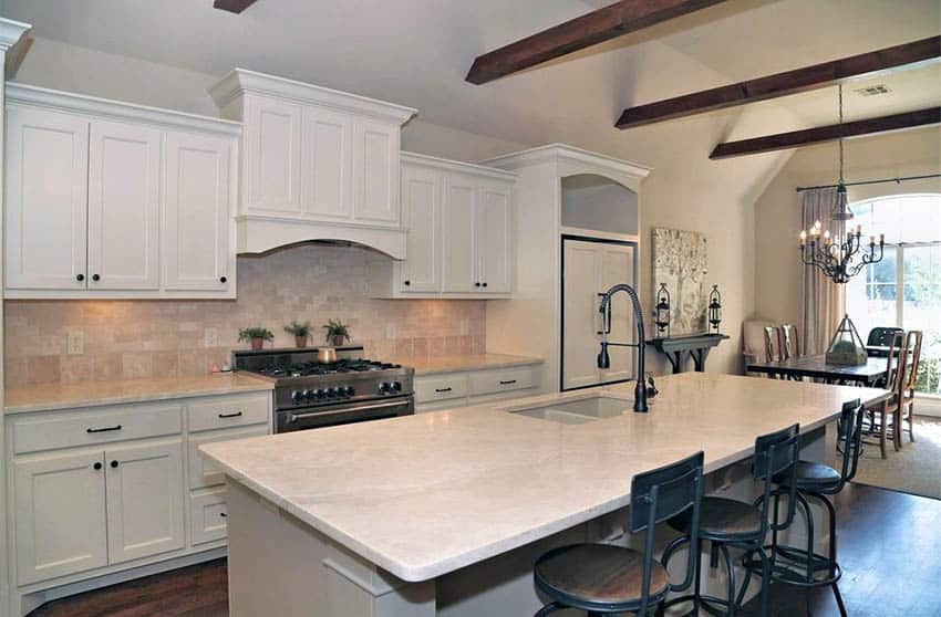 Kitchen with white cabinets and travertine countertops and backsplash