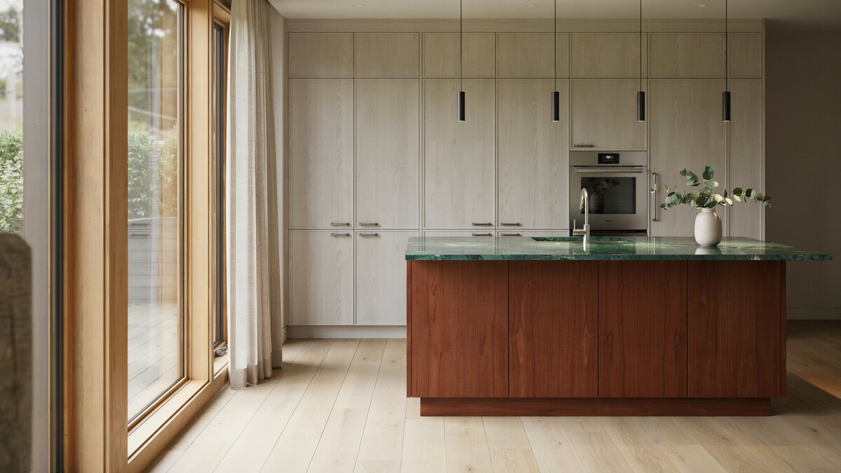 Light ash cabinetry with a mahogany island under emerald green gemstone counter