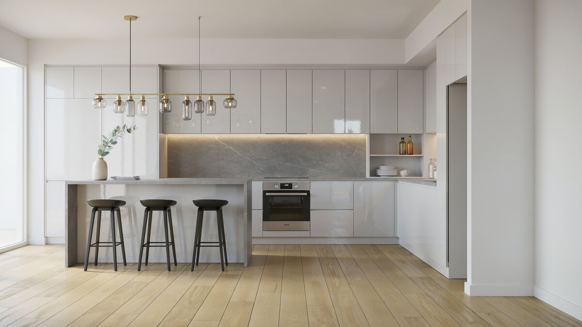 Handleless white cabinets with a gray counter and slim glass pendant lights