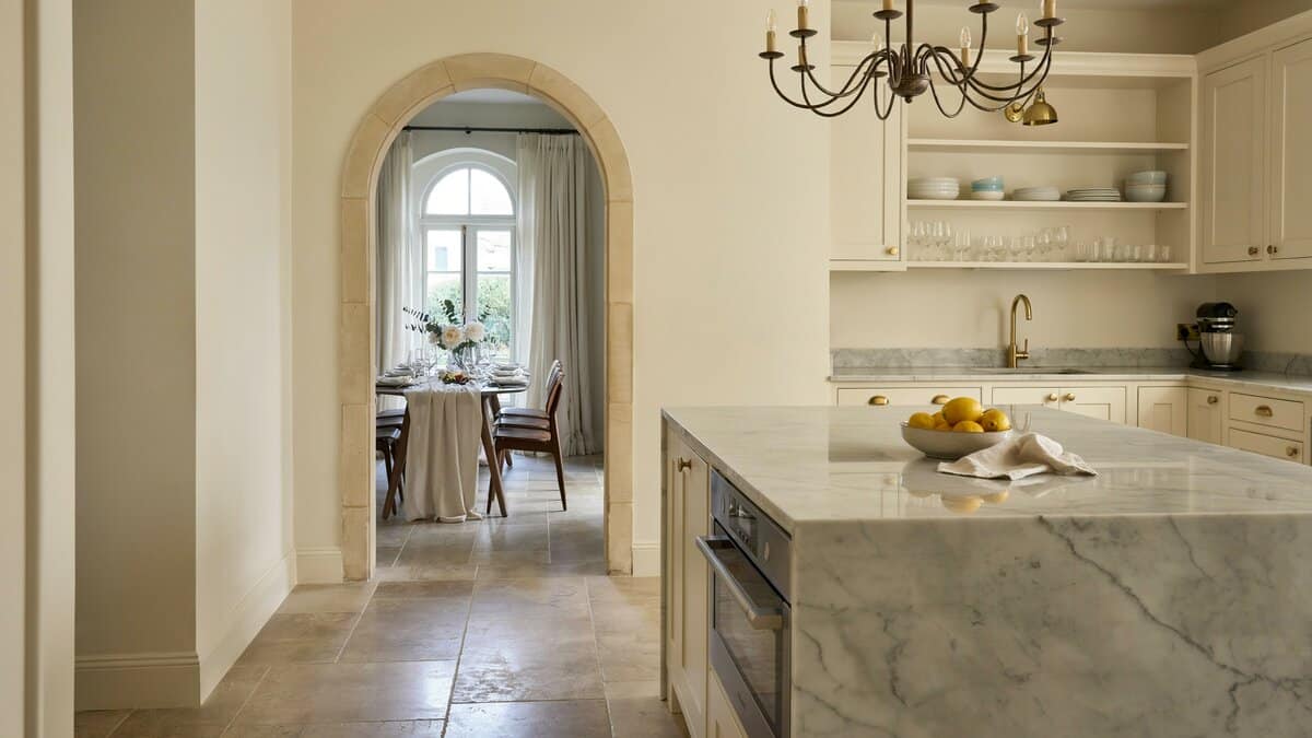 Wide arched opening to the dining room with an iron chandelier above