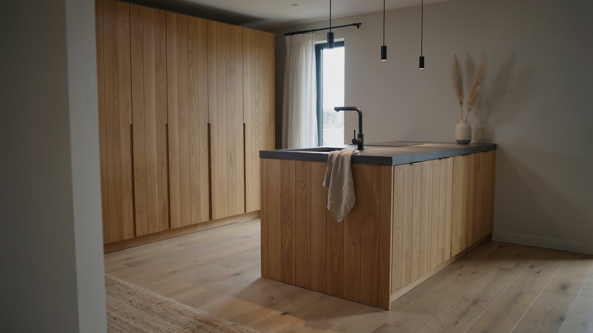Small kitchen with vertical wood plank cabinets and a dark island counter