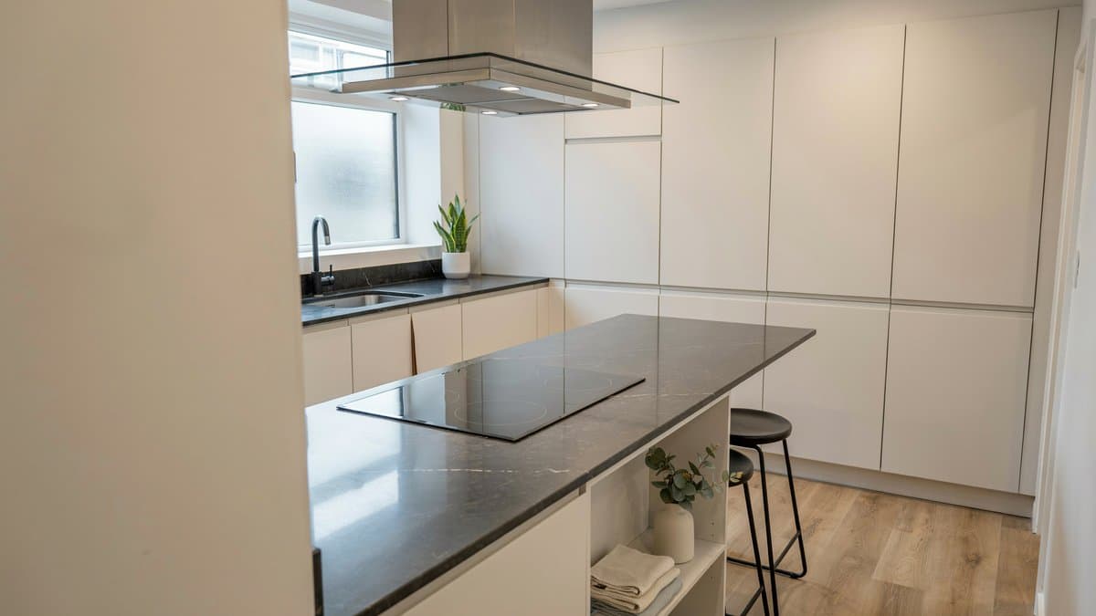 Off white wall storage with an L shape counter and glass range hood