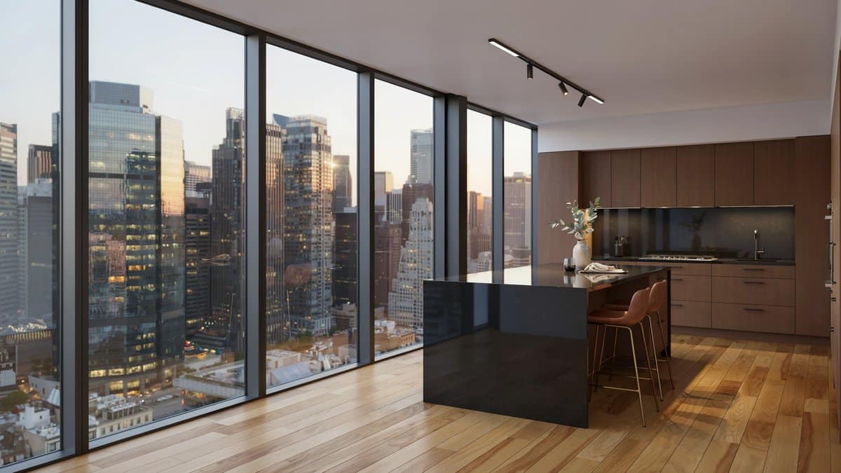 Black island in a penthouse kitchen with floor to ceiling city windows